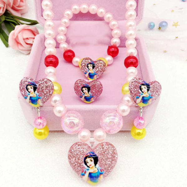 Boîte à bijoux rose ouverte avec 4 bijoux à l'effigie de Blanche Neige à l'intérieur