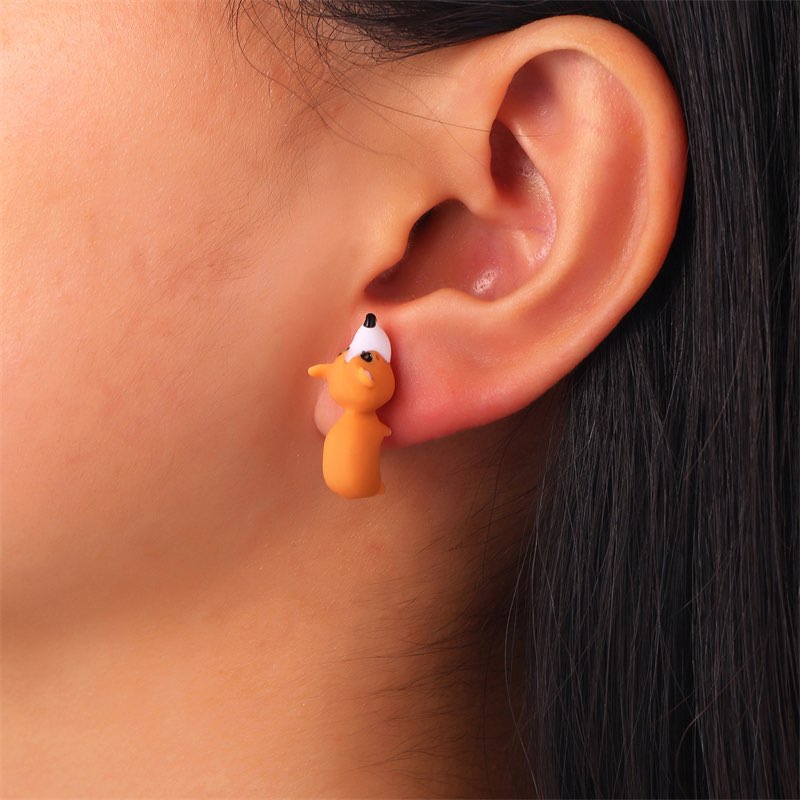 Boucle d'oreille en forme de renard portée par une femme brune