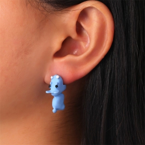 Boucle d'oreille bleue en forme d'hippopotame portée par une femme brune