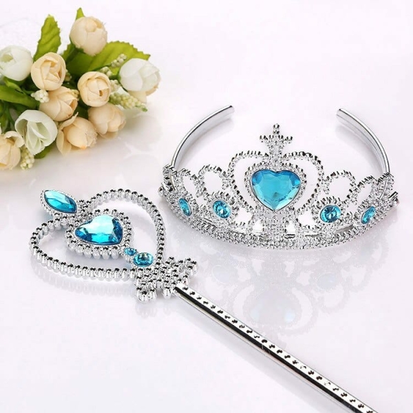 Ensemble d'une couronne et d'une baguette magique argenté et bleu, avec un bouquet de fleurs à côté