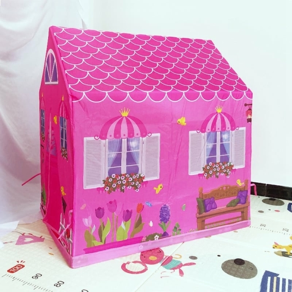 petite maison pour fille rose posé sur un tapis avec des motifs