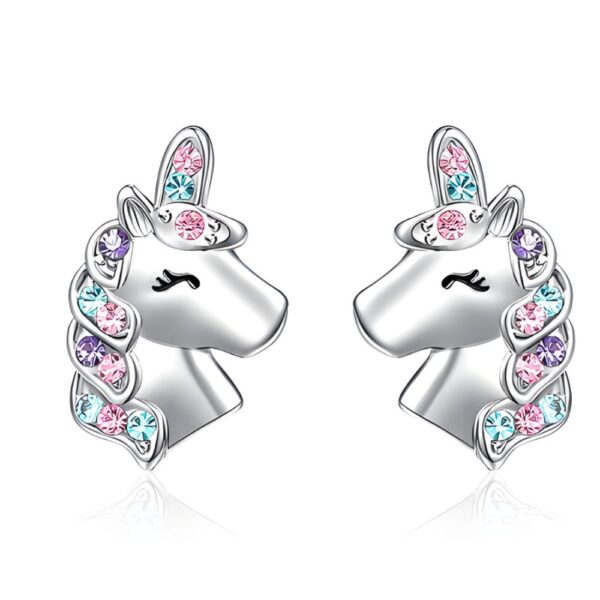 Boucles d'oreilles pour fille licorne violette à strass sur fond blanc avec une boîte à bijoux rose à côté
