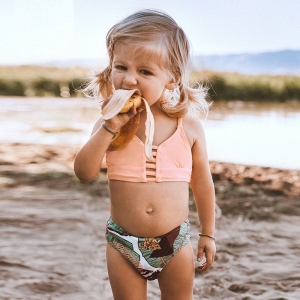 Ensemble de maillot de bain 2 pièces pour fille portée par une petite fille sur une plage.