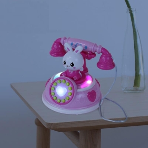 Jouet téléphonique pour petite fille, couleurs rose sur une table dans une maison