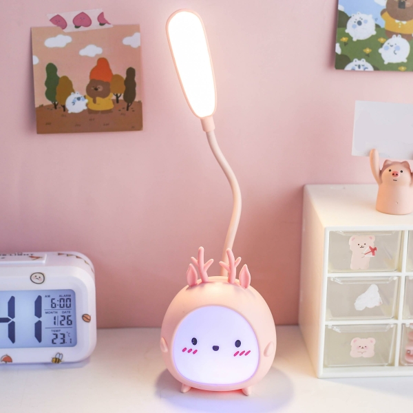 Veilleuse LED en forme de lapin pour fille couleur rose sur une table à coté d'une horloge.