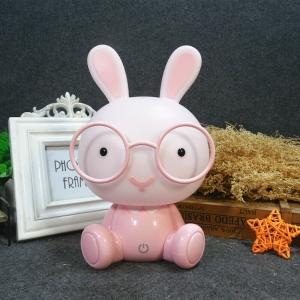 Veilleuse LED en forme de lapin à lunette pour fille rose sur une table avec une cadre blanche