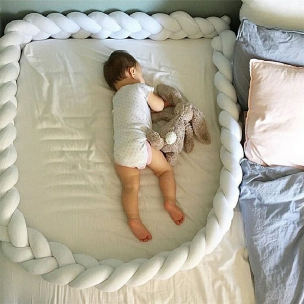 Tour de lit de protection pour berceau fille sur un lit avec un bébé à l'intérieur dans une maison