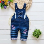 Combinaison en jean pour petite fille à la mode sur une table