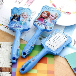 Brosse à cheveux Reine des Neiges bleue pour fille sur une table avec un cahier