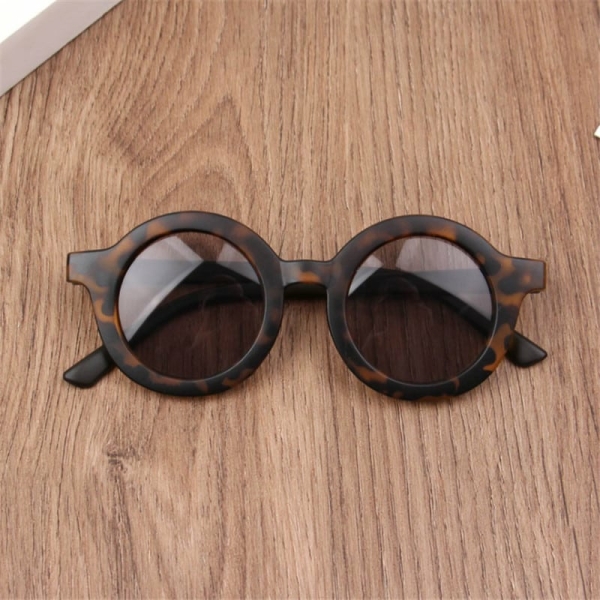 Une lunette ronde pour bébé couleur marron mise sur une superficie en bois