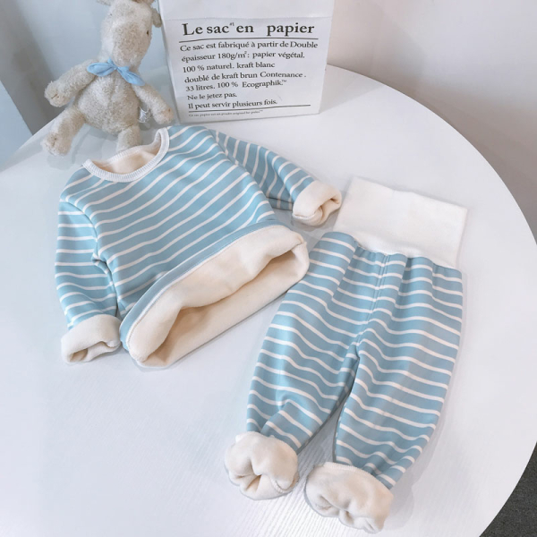 Pyjama polaire à rayures pour filles avec un nounours sur une table dans une maison