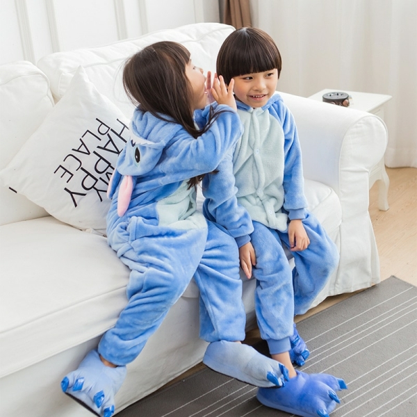 Combinaison pyjama polaire dessin animé bleu pour filles porté par une petite fille et un petit garçon sur une chaise dans une maison