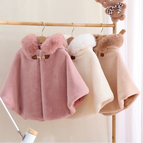 Manteaux pour fillette de couleurs rose, blanc et beige posés sur un cintre