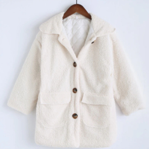 Manteau fillette en doudoune de couleur blanche posé sur un cintre marron