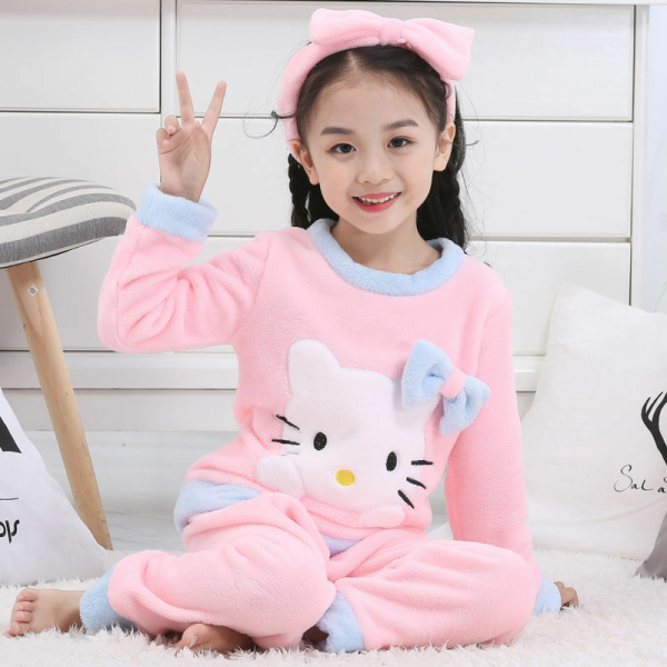 Ensemble pyjama d'hiver en polaire Hello Kitty pour fille porté par une petite fille qui porte une serre tête à la mode dans une maison