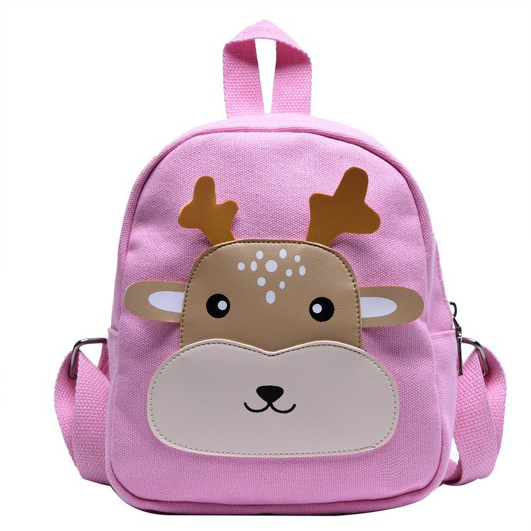 Un sac à dos rose avec un visage mignon de renne pour fille. Le visage d'animal est de couleur beige et marron. Il a une hanse sur le dessus et deux bandoulières à l'arrière.