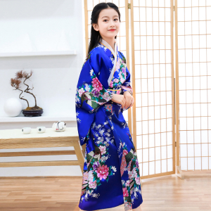 Une petite fille portant un kimono bleu fleuri.