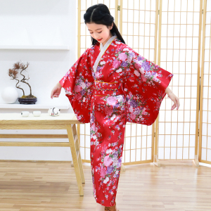jeune fille en train de se regarder, elle porte une kimono rouge avec des motifs de fleurs, elle se trouve dans une pièce au design japonais