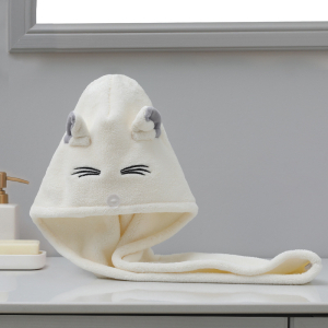 Serviette de page pour fille de couleur blanche avec un motif de chats, posé sur un meuble de salle de bain