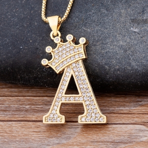 Un collier avec initial de prénom pour bébé fille avec la lettre A et au-dessus de la lettre une couronne, le collier en maillon est de couleur dorée et la lettre a et des strass,
