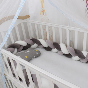 Tour de lit tressé gris et blanc pour bébé fille avec un fond un berceau de bébé avec le tour de lit