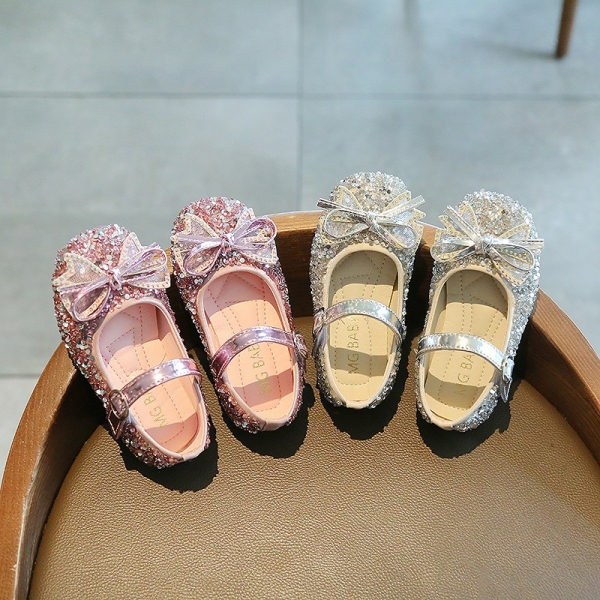 Ballerines de princesses à nœud papillon scintillant pour filles avec un fond une table avec les chaussures