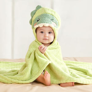 Bébé assis avec un peignoir de bain vert à capuche