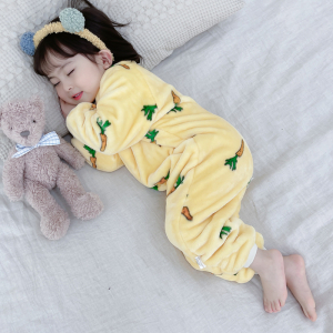 Petite fille qui dort en surpyjama jaune dans un lit, avec son doudou