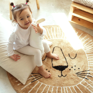 Tapis chambre de bébé style nordique en forme de lion pour fille avec une petite fille sur le tapis