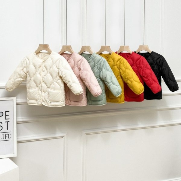 6 doudounes légères colorées suspendues devant un mur