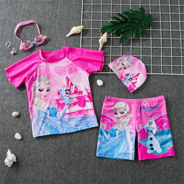 T-shirt et short de bain rose la Reine des Neiges posés à plat sur un sol gris avec un bonnet et des lunettes de bain