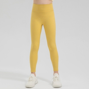 Jambes d'une jeune fille debout portant un legging de sport brillant jaune