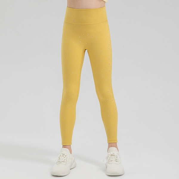 Jambes d'une jeune fille debout portant un legging de sport brillant jaune