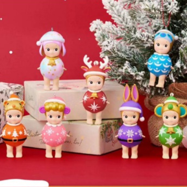 7 figurines Sonny Angel dans un décor de Noël avec un sapin et des boîtes cadeaux