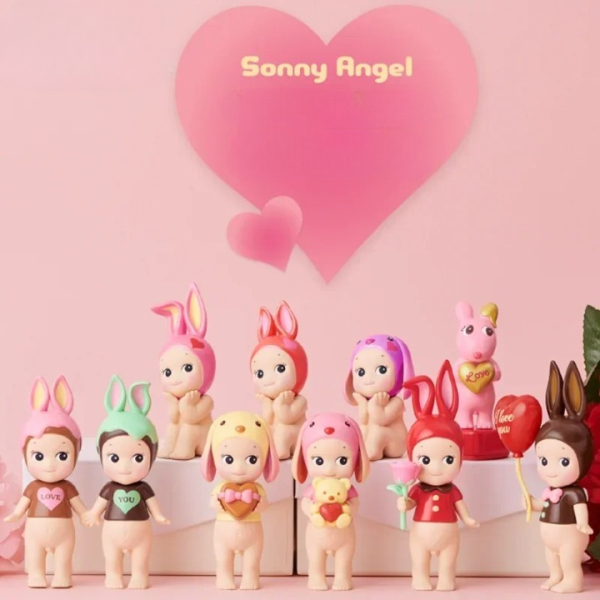 10 figurines Sonny Angel disposés les unes à côté des autres sur un fond rose avec un cœur au centre