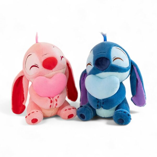 Peluche Stitch bleue en position assise tenant un cœur bleu entre ses bras, et la même en rose