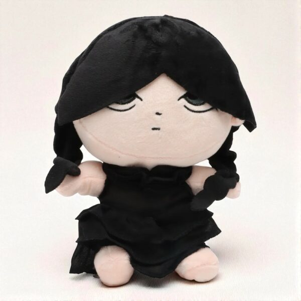 Poupée de 25 cm représentant Mercredi Addams avec une robe noire et des tresses noires, sur neutre beige