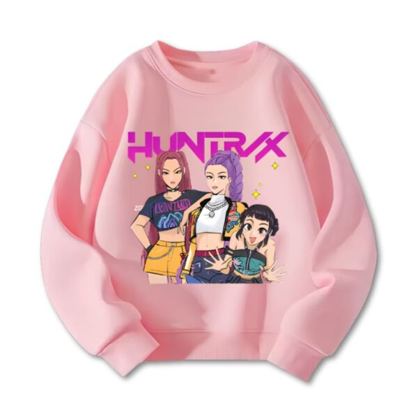 Sweat fille K-pop Demon Hunters Zoey Mira et Rumi avec Huntrix écrit en violet au-dessus d'elles. Le sweat est rose. Sur fond blanc.