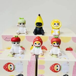 Chats Mofusand déguisés en fruits variés (fraise, citron, pomme, melon) alignés en figurines kawaii sur une étagère avec le logo Mofusand