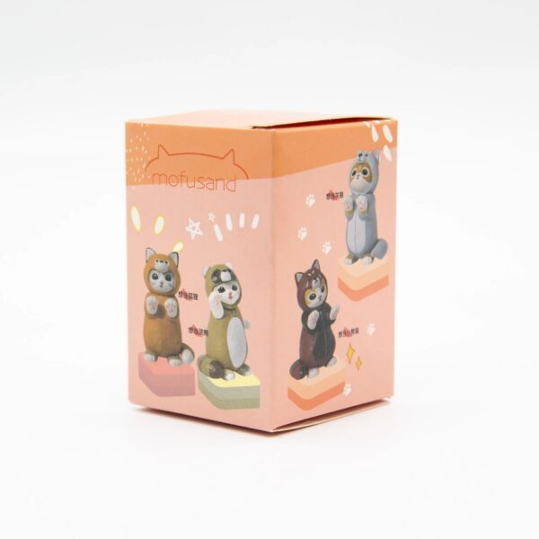 Boîte de Blind Box Mofusand avec illustrations de figurines de chats déguisés en animaux kawaii sur fond orange pastel