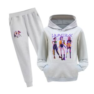 Jogging fille K-pop Demon Hunters avec sweat à capuche. L'ensemble est gris avec un motif sur la cuisse du pantalon et un gros motif avec les trois héroïnes du film sur le devant du sweat. Le sweat a une poche kangourou. Sur fond blanc.