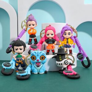 Lot de 6 porte-clés des personnages K-pop Demon Hunters en gel de silice coloré. Ils sont posés sur des supports blancs, le sol et le fond sont verts. On y retrouve les héroïnes, le tigre bleu et la pie.