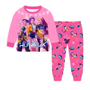 Pyjama fille K-pop Demon Hunters long deux pièces de couleur rose avec un pantalon à motifs inspirés du film et un haut à manches longues avec un motif des trois héroïnes. Sur fond blanc.