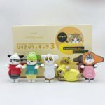Figurine chat Mofusand déguisé en vache, en tenue rouge et grise, tenue dans la main, faisant un clin d’œil, collection Sanrio Blind Box