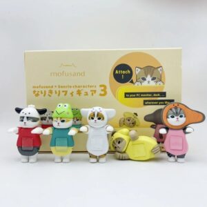 Figurine chat Mofusand déguisé en vache, en tenue rouge et grise, tenue dans la main, faisant un clin d’œil, collection Sanrio Blind Box