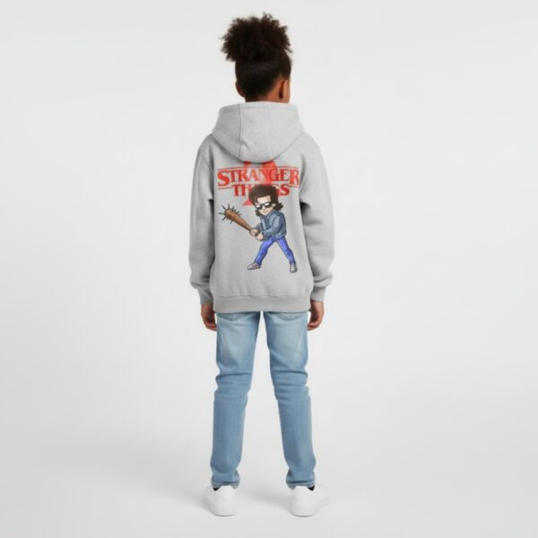 Petite fille portant un sweat Stranger things gris, sur fond gris