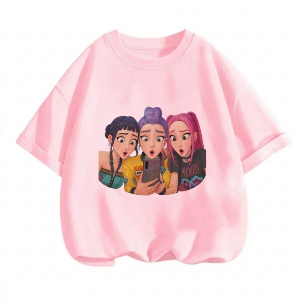 Un T-shirt fille K-pop Demon Hunters selfie surprise, rose, avec les trois personnages principaux prenant un photo, sur fond blanc simple.